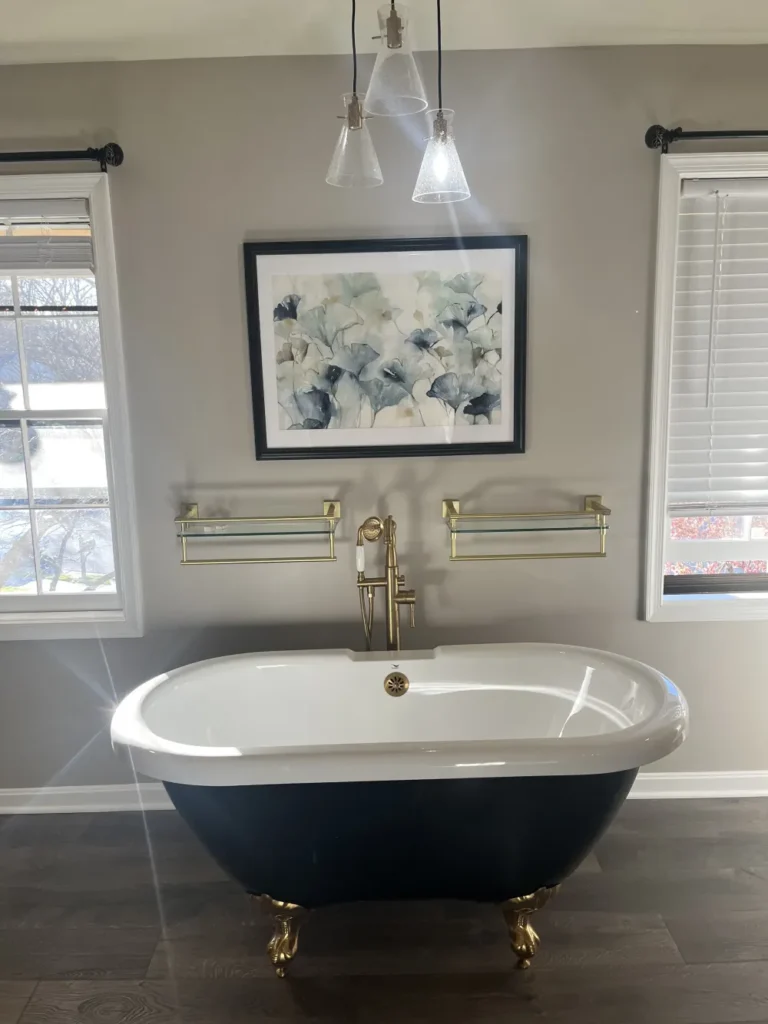 A luxurious bathroom with a gleaming black and white clawfoot bathtub and brass fixtures, showcasing the deep cleaning results of L&V Cleaning.